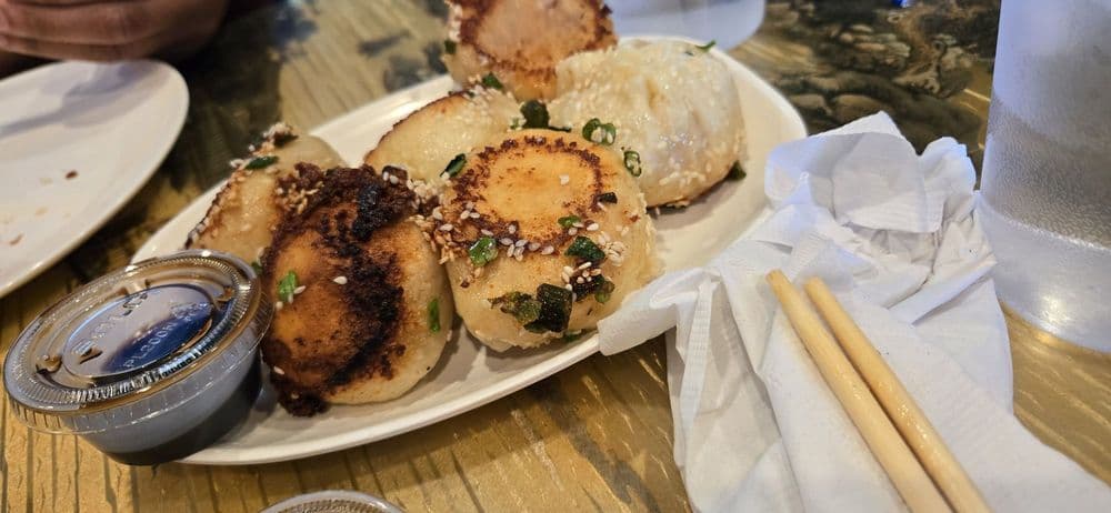 Sheng Jian Bao (生煎包) — Pan-fried pork buns with a crispy golden bottom, soft steamed top, and explosively juicy filling.